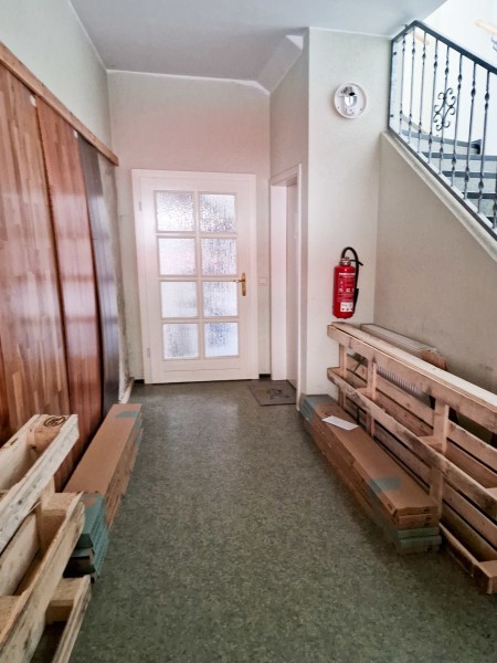 Treppenhaus mit Hintereingang zum Lagerraum und Kellertür zum WC und Keller